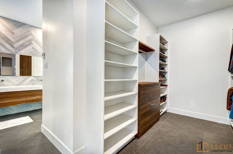 Modern walk-in closet with white shelves and wooden accents