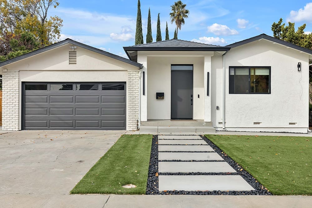 Modern white house with dark gray garage door and front door.