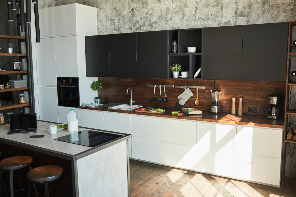 Modern kitchen with white and black cabinets, wood backsplash, and central island.